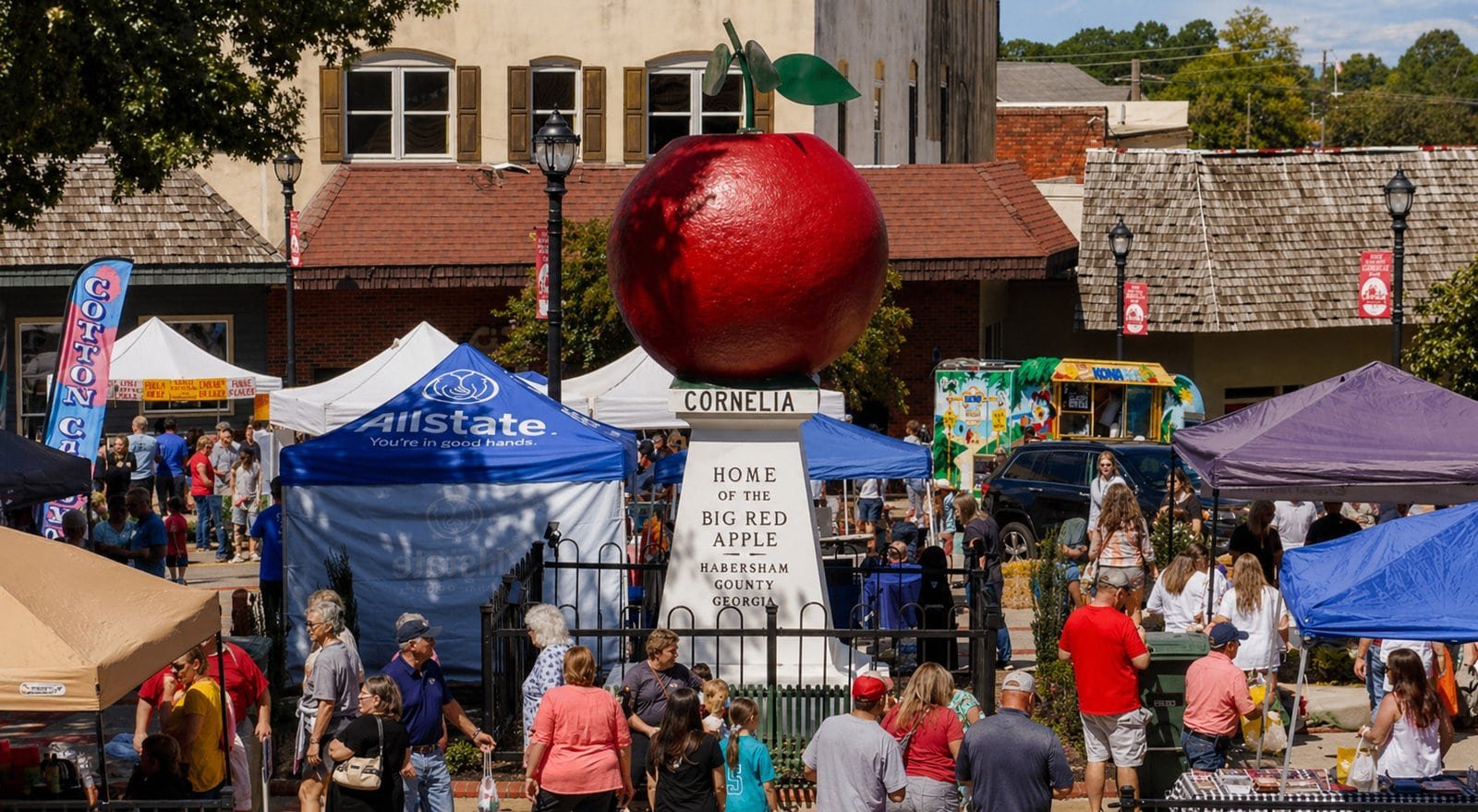 Festival in Cornelia, GA featuring a large red apple sculpture and local vendors.