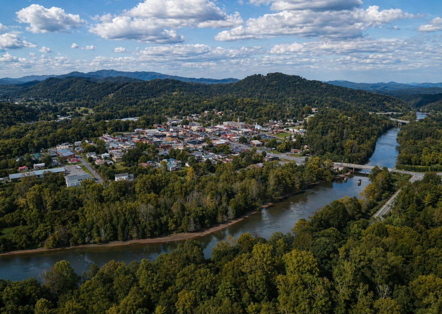 Aerial view of Murphy, NC with the river and lush green hills surrounding the town.