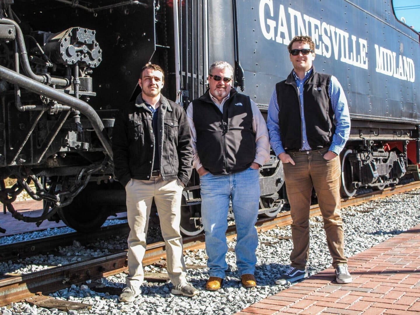 Historic train with three men standing on railway tracks at Gadsden, Alabama.