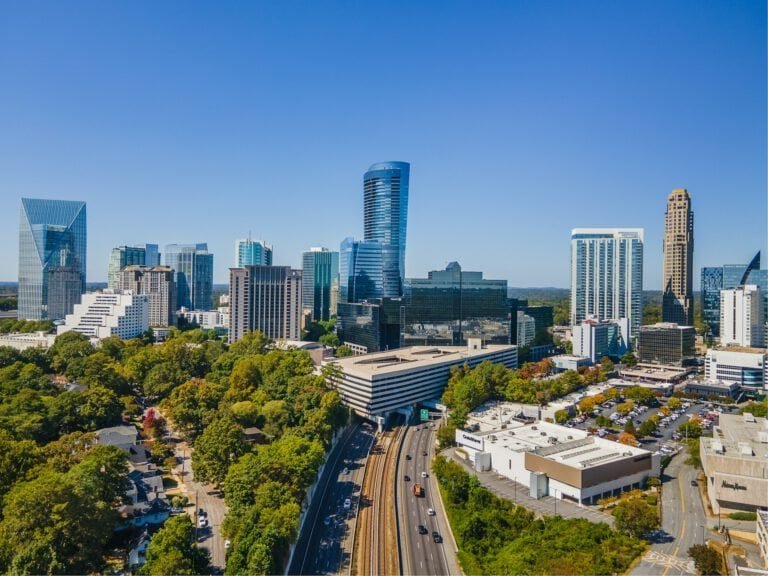 Cityscape featuring tall buildings, lush trees, and busy roads in Charlotte, North Carolina, showcas.