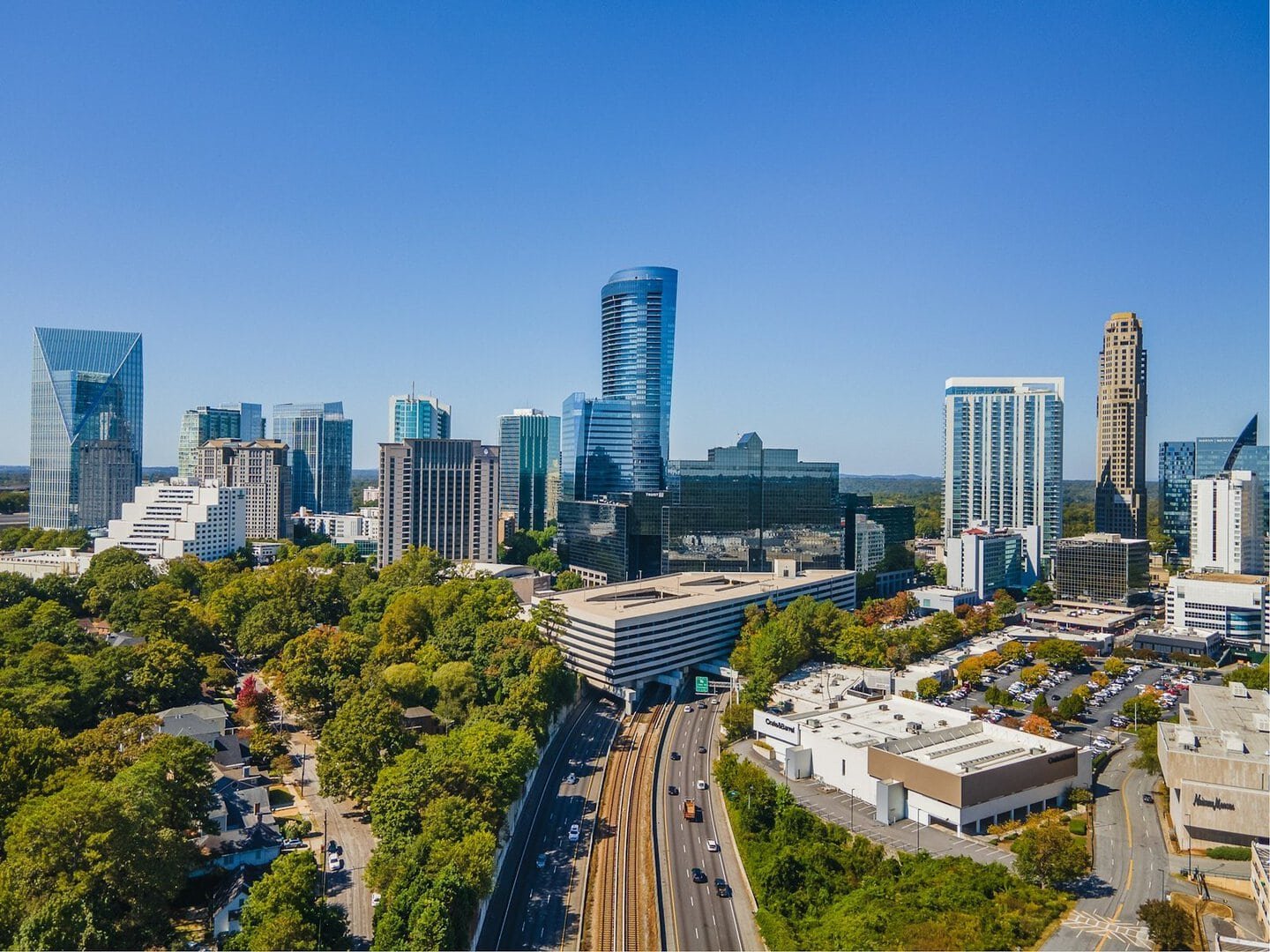 Cityscape featuring tall buildings, lush trees, and busy roads in Charlotte, North Carolina, showcas.
